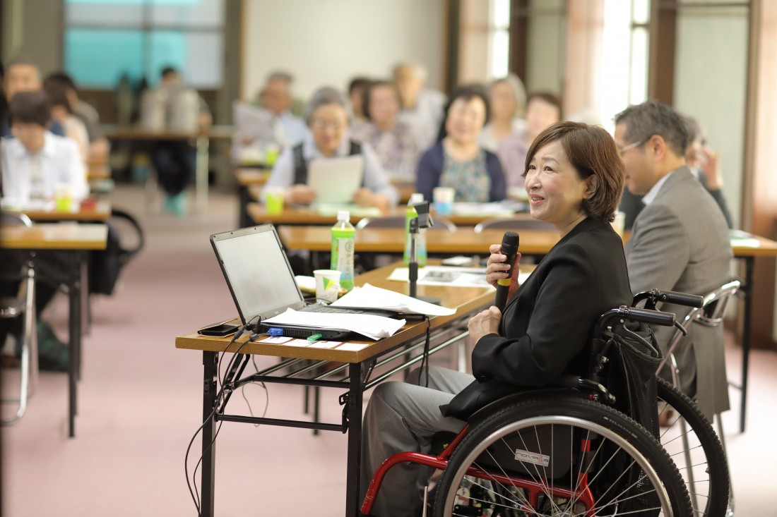 車椅子の講師が講演している写真